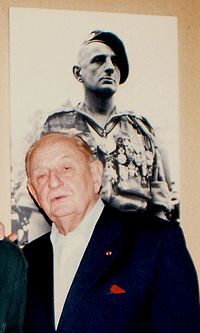 Le général Marcel Bigeard en octobre 1996, la photo derrière lui a été prise 40 ans auparavant