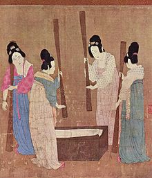 Peinture de quatre femmes chinoises vêtues de robes de soie colorées. Leurs cheveux sont noués dans un chignon. Les femmes sont debout autour d'un petit bloc de bois, avec de la soie étendue dessus. Les femmes battent la soie avec de grands fouets.