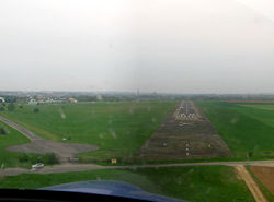 Atterrissage avec la Cathédrale d'Amiens à l'horizon et les hangars de l'aérodrome juste à gauche.