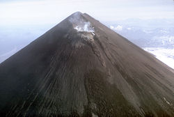 Vue aérienne du mont Pavlof montrant son cratère sommital fumant.
