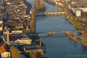 Vue sud du centre-ville traversé par la Vienne, avec l'ancienne Manufacture d'Armes et le pont Camille de Hogues (en bas), et le pont Henri IV (en haut)