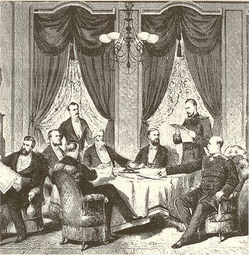 Dessin noir et blanc montrant des civils et des militaires, certains assis, d'autres debouts, autour d'une table, examinant et discutant les documents objets du traité.