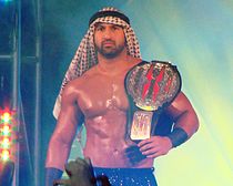 Shiek Abdul Bashir tenant la ceinture du TNA X Division Championship.