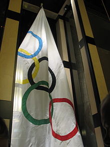 Un drapeau blanc suspendu avec les cinq anneaux entrelacés, symbole des Jeux olympiques.