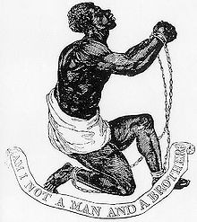 Dessin d'un esclave noir agenouillé et levant ses mains attachées et enchaînées. Sous lui, une bannière dit "Am I Not a Man and a Brother?"