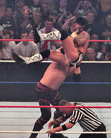 Kane portant un Chokeslam sur CM Punk.