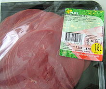 Barquette présentant des tranches fines de viande de couleur rose foncée.