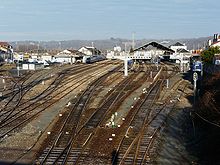 Vue d'ensemble de l'intérieur de la gare, avec les voies, les quais et les bâtiments