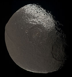 Mosaïque d'images de Japet prises par la sonde Cassini le 31/12/2004 montrant la zone sombre Cassini Regio, sa frontière avec la zone lumineuse Roncevaux Terra, plusieurs grands cratères et la crête équatoriale.