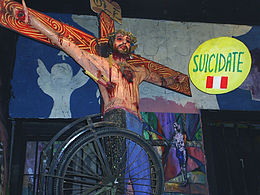  Photo montrant une crucifixion de Jésus qui porte des banderilles, au dessus de sa tête se trouve un panneau.