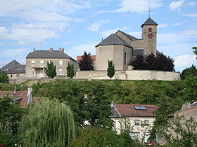 Le presbytère, l'Église et le Rocher, vus depuis une rue du vieux village