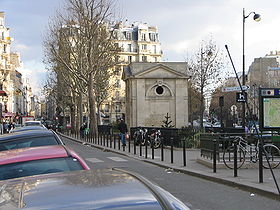 Vue de l'intersection des rues du Faubourg-Saint-Antoine et de Montreuil ; la fontaine de Montreuil est le bâtiment rectangulaire en centre de la photographie.