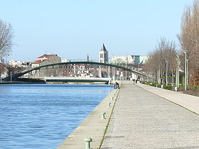 Le Canal Saint-Denis, le pont tournant, la passerelle du Stade de France et, au fond, la basilique Saint-Denis.